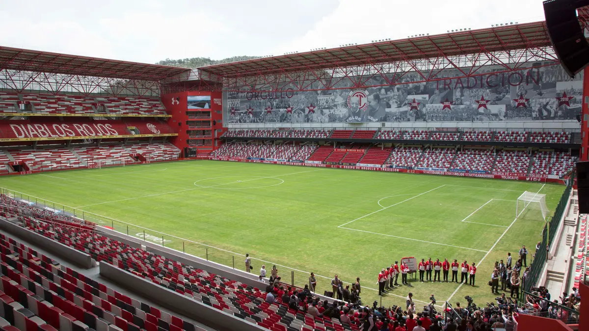 Interior del Estadio Nemesio Díez de Toluca con la cancha, gradas rojas y blancas y la leyenda Diablos Rojos en una tribuna