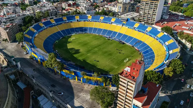 Vista aérea del Estadio Ciudad de los Deportes, con sus gradas amarillas y azules, rodeado de edificios en la Ciudad de México
