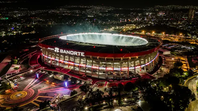 Vista aérea nocturna del Estadio Banorte, antes Estadio Azteca, iluminado y rodeado por las luces de la Ciudad de México