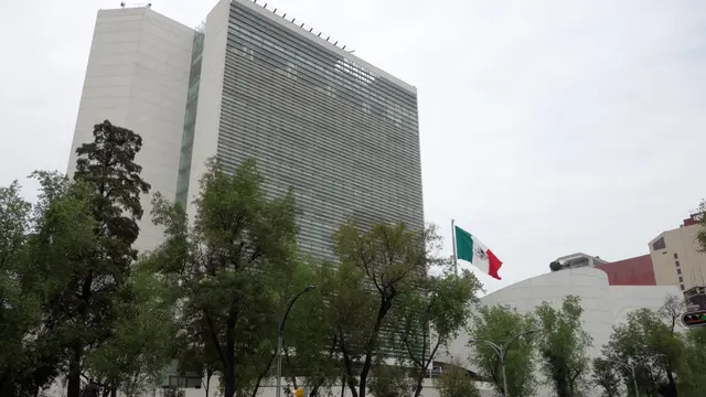 Edificio del Senado de la República en la Ciudad de México, con una bandera de México ondeando y árboles al frente