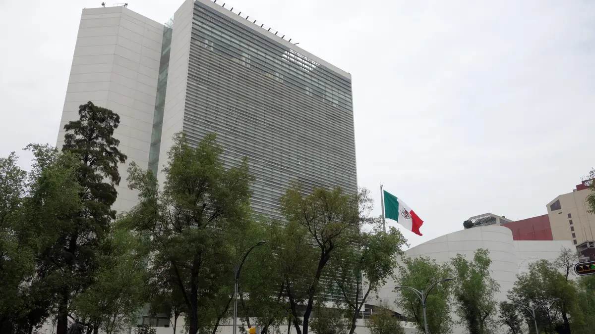 Edificio del Senado de la República en la Ciudad de México, con una bandera de México ondeando y árboles al frente