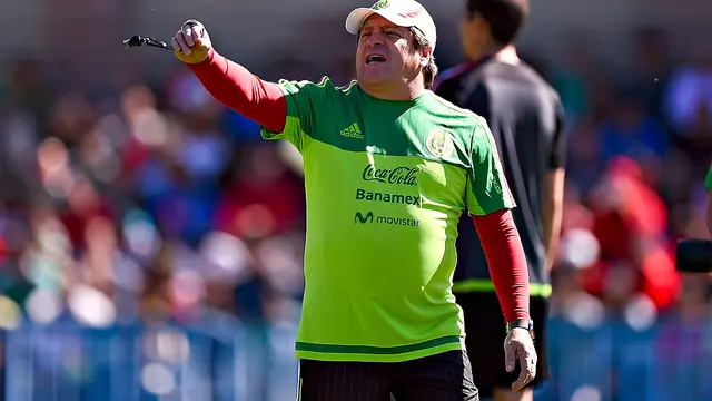 Miguel Herrera con ropa de entrenamiento de la Selección Mexicana da indicaciones con el brazo extendido durante una práctica