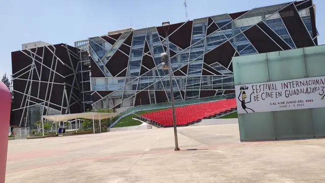 Biblioteca Pública del Estado de Jalisco Juan José Arreola, en la zona del Centro Cultural Universitario de Zapopan, con su fachada de vidrio y una gradería roja al aire libre