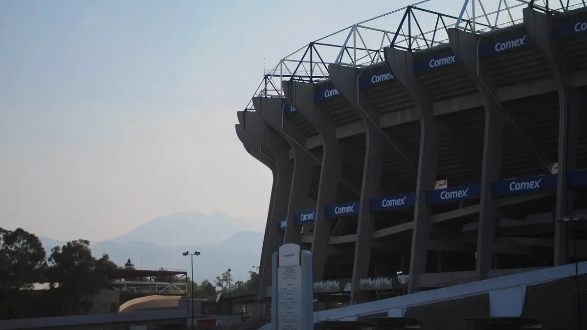Exterior del Estadio Azteca, hoy Estadio Banorte, con sus columnas de concreto y montañas al fondo en la Ciudad de México