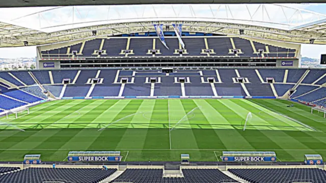 Interior del Estádio do Dragão, casa del Porto, con la cancha regándose y las gradas azules vacías