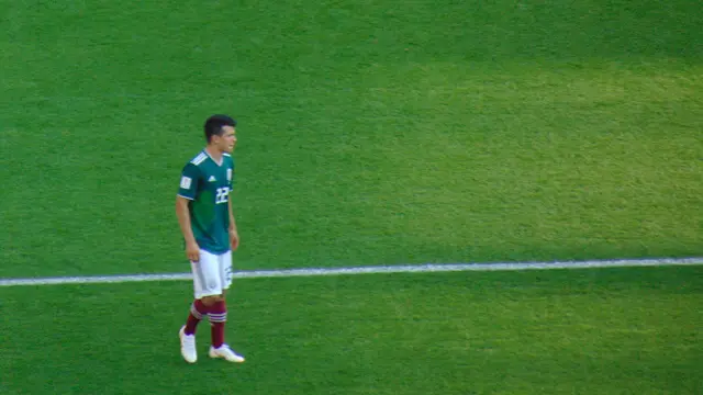 Hirving Lozano con el uniforme verde de la Selección Mexicana, de pie sobre la cancha durante el Mundial de Rusia 2018
