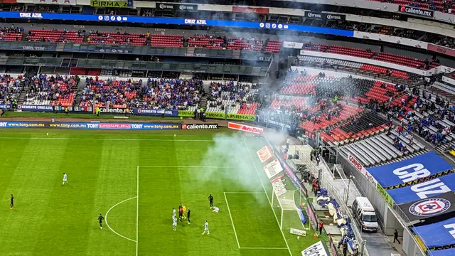 Partido de Cruz Azul contra Santos Laguna en la Liga MX en 2023 visto desde la tribuna, con humo en la cancha y aficionados en las gradas