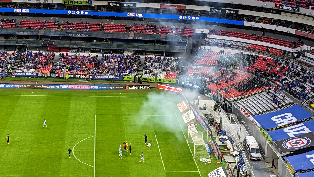 Partido de Cruz Azul contra Santos Laguna en la Liga MX en 2023 visto desde la tribuna, con humo en la cancha y aficionados en las gradas