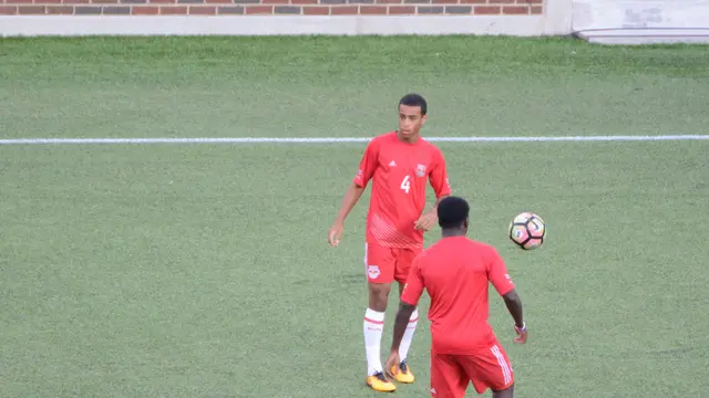 Tyler Adams, con el número 4 y uniforme rojo, calienta con balón junto a un compañero antes de un partido de la U.S. Open Cup en 2017