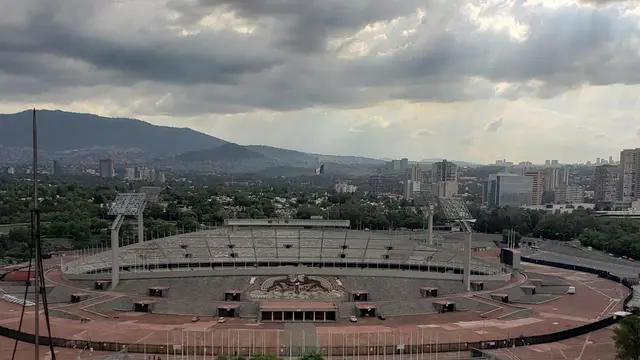 Estadio Olímpico Universitario visto desde lo alto, con nubes grises sobre Ciudad Universitaria y el sur de la Ciudad de México