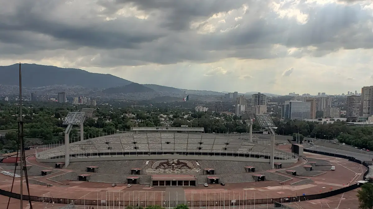 Estadio Olímpico Universitario visto desde lo alto, con nubes grises sobre Ciudad Universitaria y el sur de la Ciudad de México