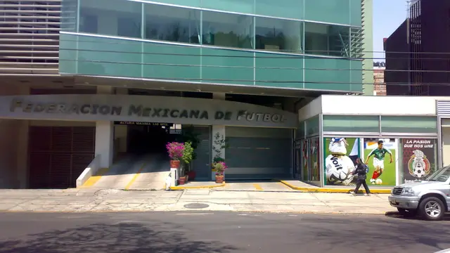 Fachada de un edificio de la Federación Mexicana de Futbol con el nombre del organismo en letras metálicas y carteles de la Selección Mexicana