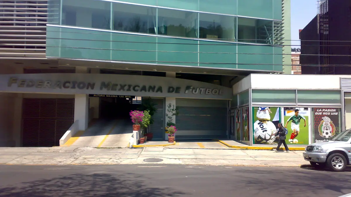 Fachada de un edificio de la Federación Mexicana de Futbol con el nombre del organismo en letras metálicas y carteles de la Selección Mexicana