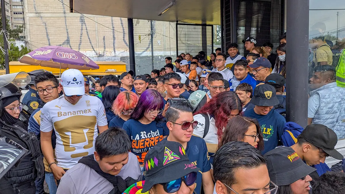 Multitud de aficionados de Pumas, algunos con la playera del club, en la entrada del Metro Copilco en la Ciudad de México