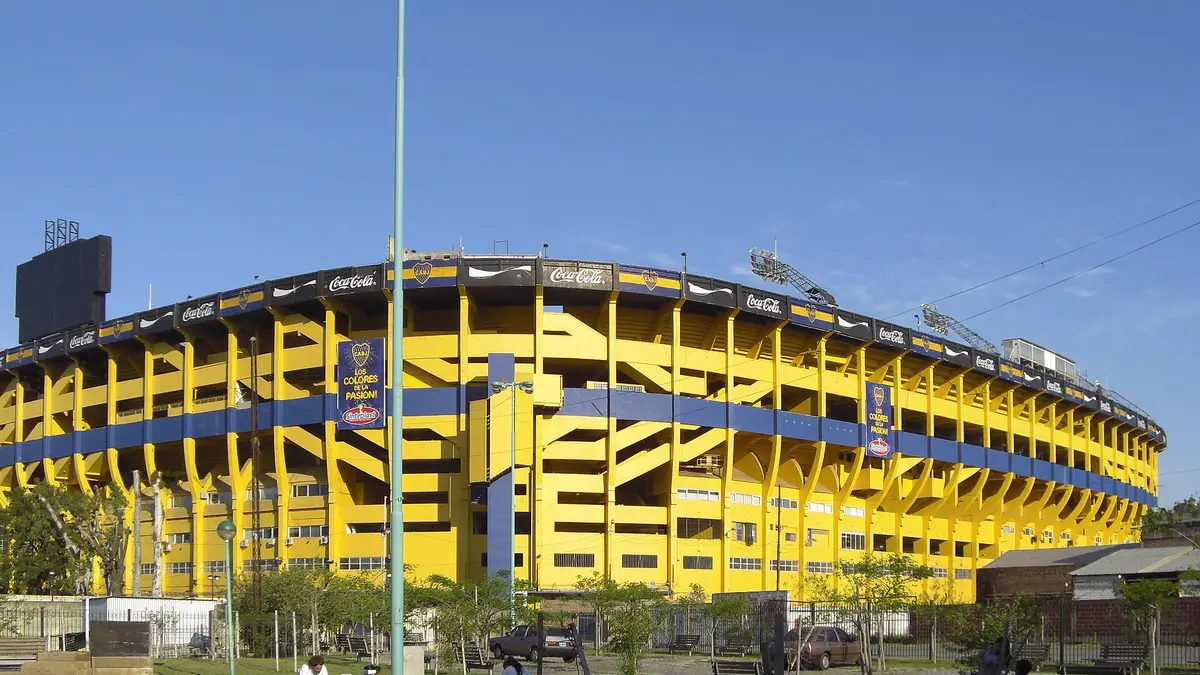 Exterior de La Bombonera, el estadio de Boca Juniors en Buenos Aires, con sus tribunas amarillas y azules bajo un cielo despejado