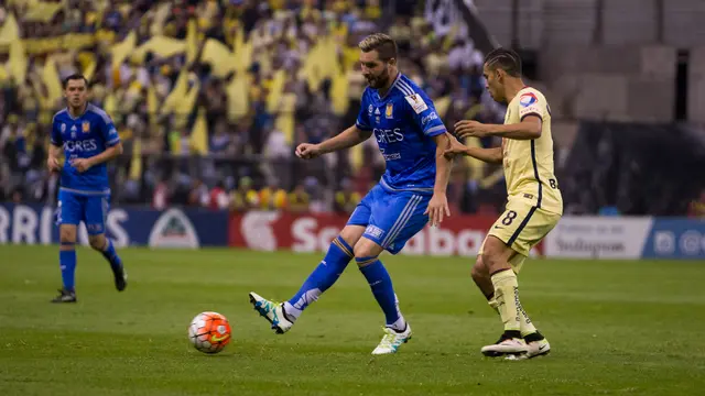 André-Pierre Gignac, con el uniforme azul de Tigres, pasa el balón frente a un jugador del América en la final de la Concacaf 2016