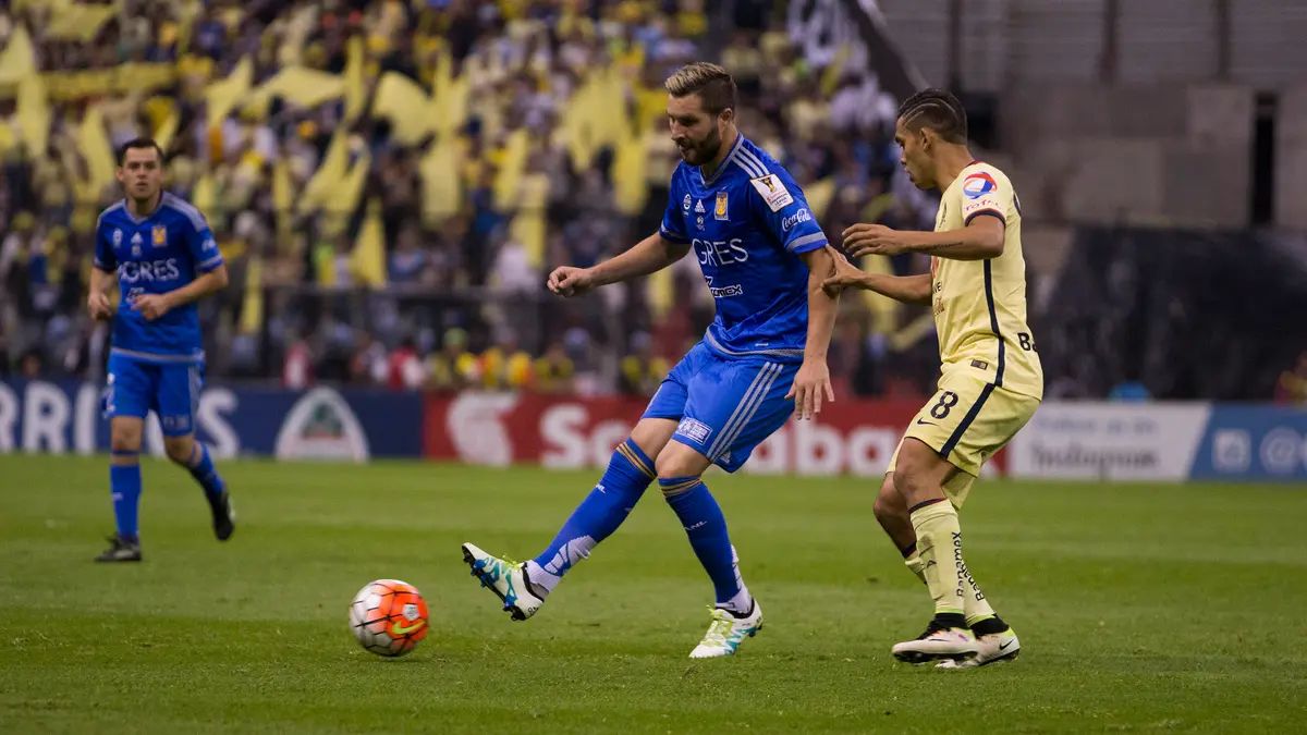André-Pierre Gignac, con el uniforme azul de Tigres, pasa el balón frente a un jugador del América en la final de la Concacaf 2016
