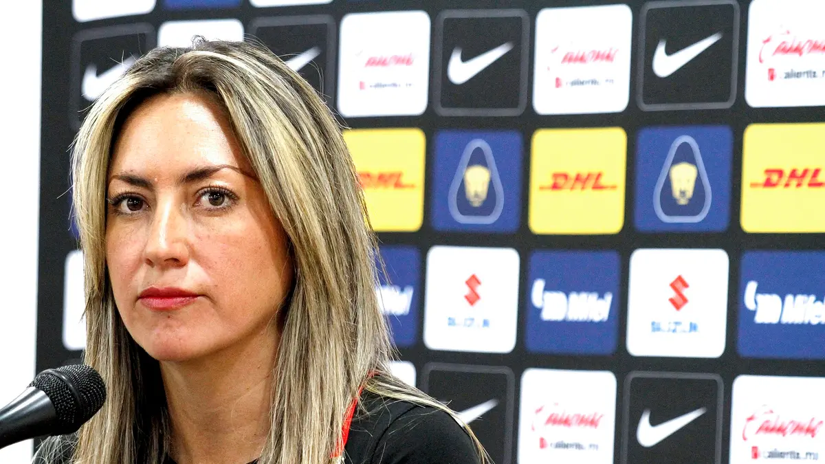 Ileana Dávila en una conferencia de prensa frente a un micrófono, en 2020, cuando dirigía a Pumas Femenil