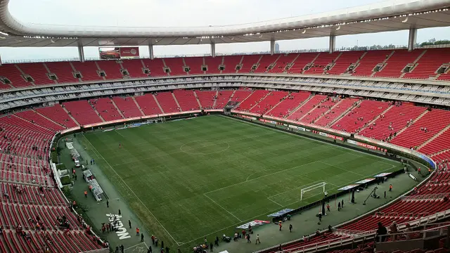 Interior del Estadio Akron de Guadalajara, casa de Chivas, con gradas rojas vacías y la cancha vista desde lo alto