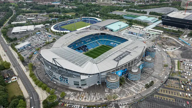 Vista aérea del Etihad Stadium, casa del Manchester City, con la cancha y las gradas azules