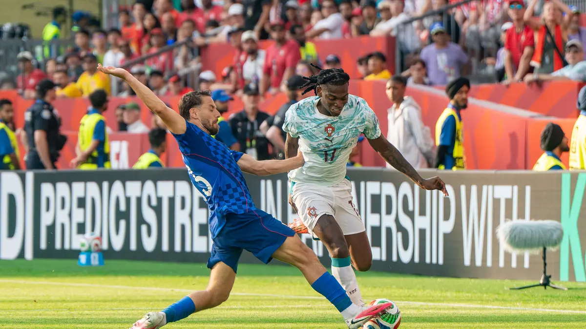 Rafael Leão, con la camiseta blanca de Portugal y el número 17, conduce el balón ante la barrida de un jugador de Croacia