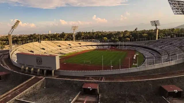 Vista aérea del Estadio Olímpico Universitario en Ciudad Universitaria, con la cancha, la pista de atletismo y las gradas vacías al atardecer