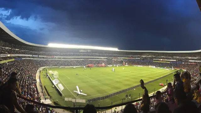 Vista panorámica de noche del Estadio Corregidora de Querétaro, con la cancha iluminada y las gradas llenas de aficionados