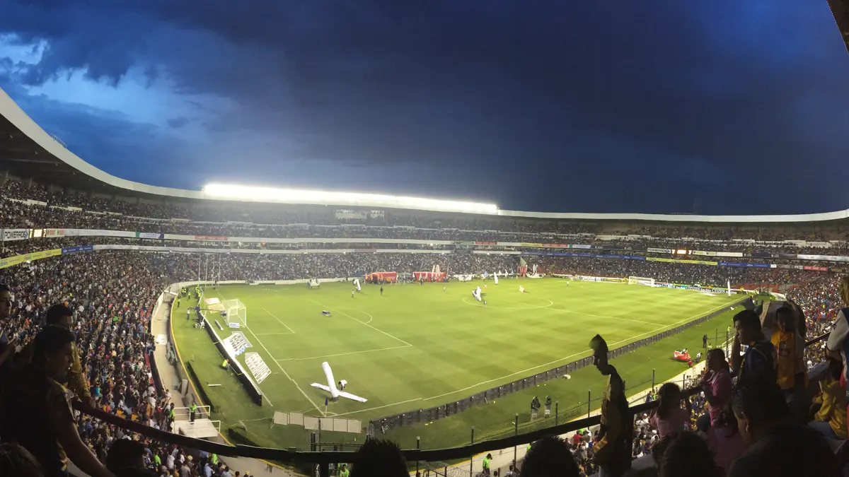 Vista panorámica de noche del Estadio Corregidora de Querétaro, con la cancha iluminada y las gradas llenas de aficionados