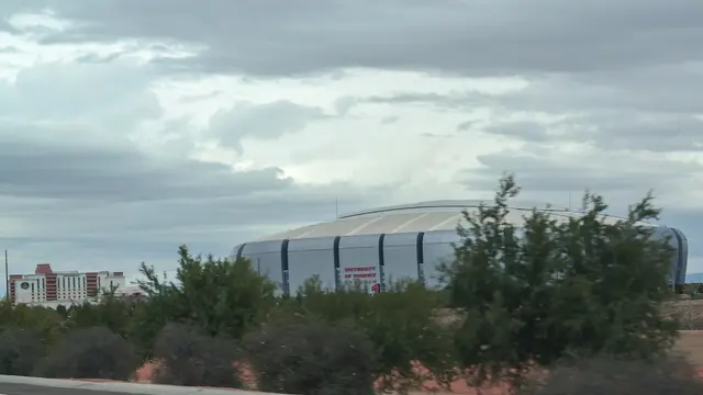 El estadio de Glendale, Arizona, visto a lo lejos desde la carretera bajo un cielo nublado y gris