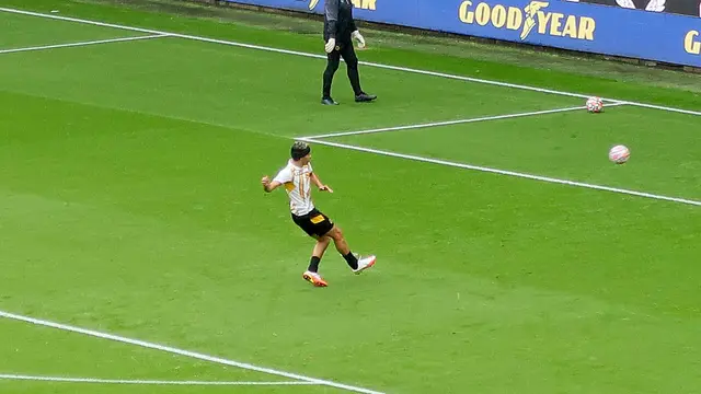 Raúl Jiménez, con uniforme de entrenamiento del Wolverhampton y banda protectora en la cabeza, golpea el balón en la cancha antes de un partido