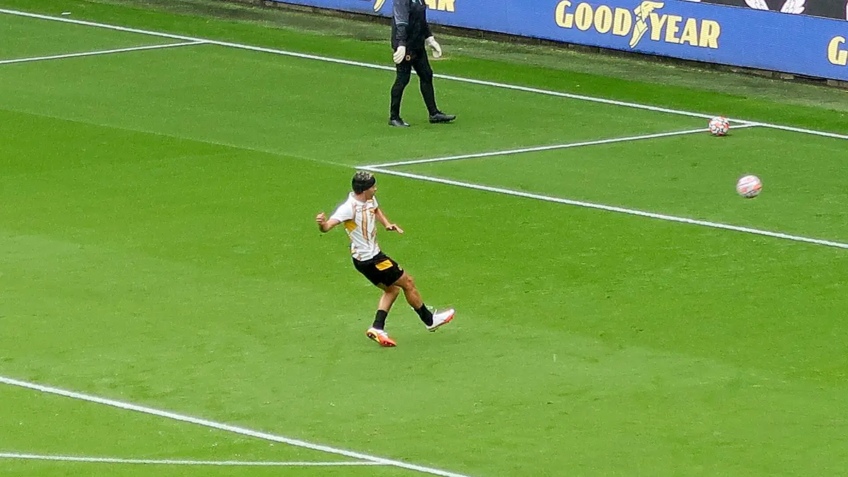 Raúl Jiménez, con uniforme de entrenamiento del Wolverhampton y banda protectora en la cabeza, golpea el balón en la cancha antes de un partido