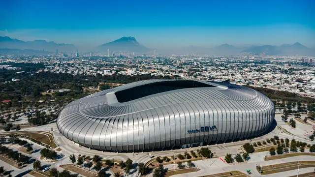 Vista aérea del Estadio BBVA en Guadalupe, Nuevo León, con la ciudad de Monterrey y sus montañas al fondo