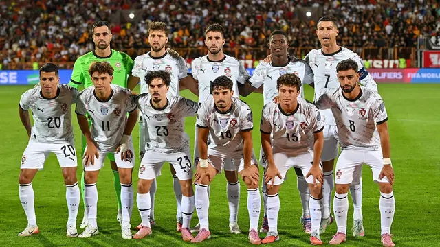 Foto de equipo de la selección de Portugal con uniforme blanco antes de un partido, con Cristiano Ronaldo de pie en la fila de atrás y Bruno Fernandes al frente