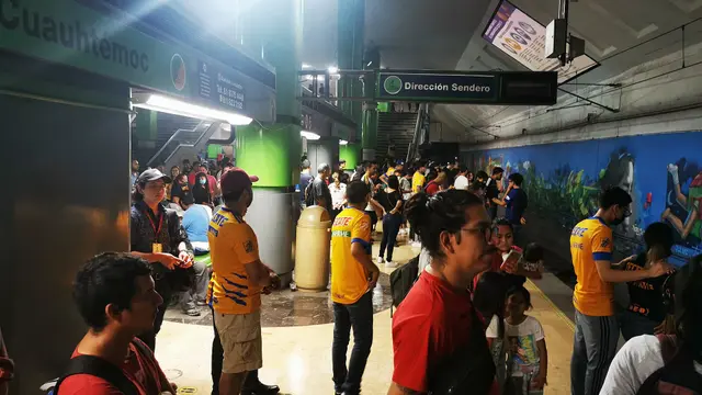 Aficionados con playeras amarillas de Tigres esperan en el andén de la estación Cuauhtémoc del Metrorrey, rumbo al estadio