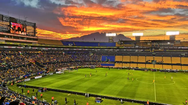 Atardecer naranja sobre el Estadio Universitario de la UANL con el Cerro de la Silla al fondo durante un partido de Tigres