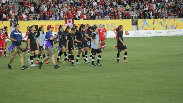 Jugadoras de la Selección Mexicana Femenil con uniforme negro caminan por la cancha tras un partido ante Canadá en los Juegos Panamericanos 2015