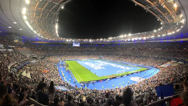 Interior del Stade de France de noche, con las gradas llenas y una lona de la Nations League sobre la cancha